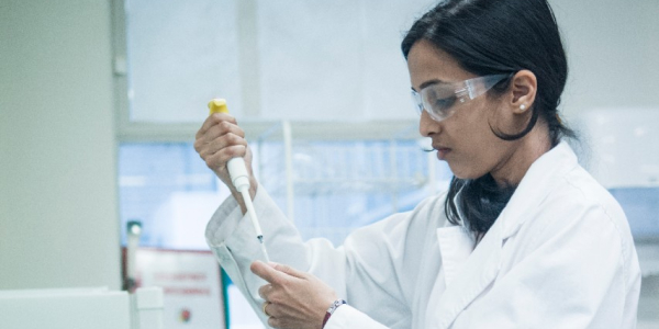 Student in a lab, extracting from a tube